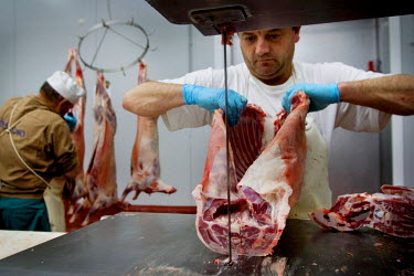 A Halal butcher cutting up meat.