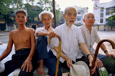 A group of elderly men sitting on a bench.