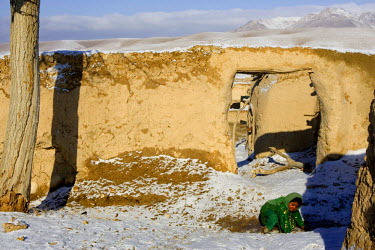 A girl wearing a green dress slips on a piece of ice in front of her compound. The winter of 2008 was one of the coldest winters recorded in Afghanistan.