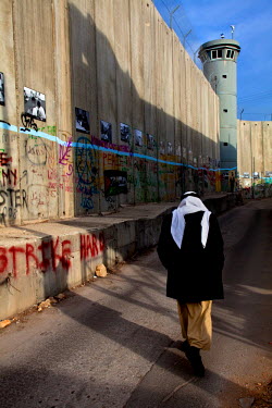 A man walks alongside the Israeli separation wall.