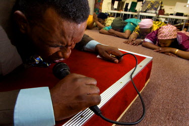 A minister of Congolese origin preaching in a church established in a converted garage.