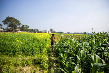 Ankoor runs through fields near his house to demonstrate how ran through fields like this after escaping from child traffickers.
