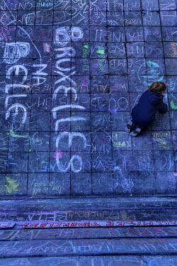 A girls draws a tribute in chalk on the ground in front of the Bourse (Stock Exchange) to those killed in the Brussels terrorist attacks.  On 22 March 2016 two terrorist suicide attacks - at Brussels'...