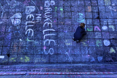 A girls draws a tribute in chalk on the ground in front of the Bourse (Stock Exchange) to those killed in the Brussels terrorist attacks.  On 22 March 2016 two terrorist suicide attacks - at Brussels'...
