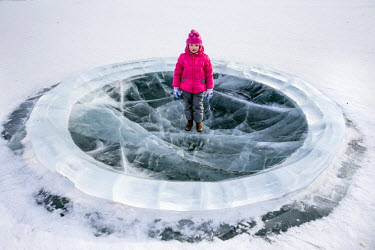 A young girl stands in a playground made entirely of ice in Yakutsk, the coldest city on earth and the only major settlement on earth built on permafrost.