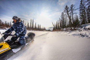 Yegor Dyachkovsky driving a snowmobile as he assists Ion Maxsimovic during a wolf hunt. Ion decribes Yegor as: 'A quiet man, but he works hard'.  An explosion of the wolf population has had a devastat...