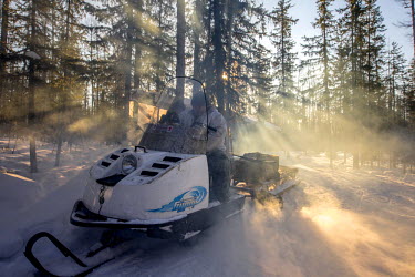 Hunter, Ion Maxsimovic revs up the engine of his snowmobile in order to warm it up on a typically cold morning. Temperatures in the region can get as low as minus 50 degrees celsius.