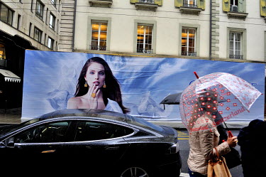 A model displayed on a giant hoarding hiding preparations for a luxury jewellery boutique about to open on Rue du Rhone in the centre of the city. This street is lined with luxury stores, mostly for a...