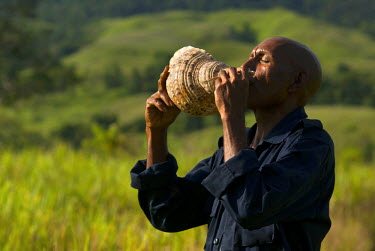 40 year old Antipas Kirwang blows a conch shell, traditionally used to warn communities of emergencies (flooding, tsunamis et cetera).