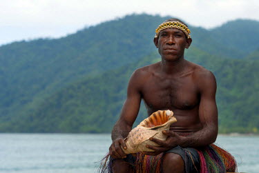 Sua Kembos (Lambu people of the Bong tribe) with a conch shell, blown to warn villagers of disaster.