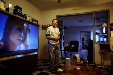 John Bryant (35) stands beside a huge television at his home in Delray. Hard.Landis a journey through rust belt and blue collar America to meet the people struggling to keep the 'American Dream' alive...