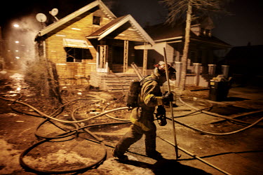 Firefighters extinguish a house fire. With at least 70,000 abandoned buildings and 31,000 empty houses fires occurs several times every night. Hard.Land is a journey through rust belt and blue collar...