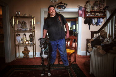 James London, AKA Big Jim, at home with one of his dogs. He started a neigbourhood watch in Youngstown after he moved there following a jail sentence for drug trafficking. 'This neighbourhood was a me...