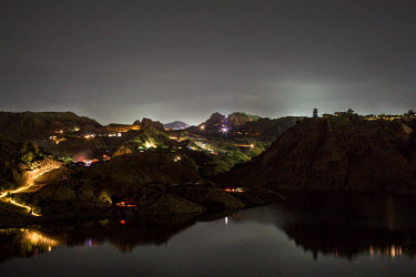 The landscape of a jade mine by night. Some miners work by night and some by day but the mines never get a rest.