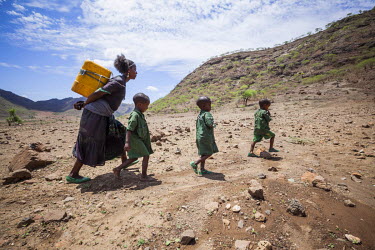 Degese Zarsaya, 18, takes her brothers and sisters to collect water from a newly dug well near her home. They fetch 10 jerry cans a day, a total of 200 litres, most of which is for the family's five c...