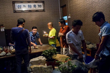 Chinese traders negotiate at a shop which deals in raw jade smuggled from Myanmar . According to several Myanmar black market jade traders almost all the raw jade traded in Yin Jiang are smuggled dire...