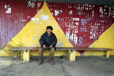80 year old Nikolai waits for a bus at the bus station in Suvyd.