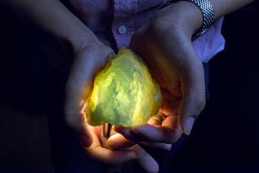 A trader shows a jade stone, which he estimates to be worth at least forty or fifty thousand USD on the black market, in a hotel room in Yin Jiang, Yunnan Province, China. According to several Myanmar...