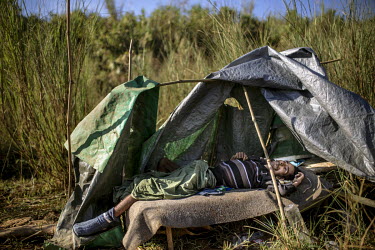 A heroin-addicted jade miner lies dead inside his makeshift tent close to a 'shooting gallery' near a jade mine. Heroin is almost openly available in Hpakant with jade miners lining up for a shot whic...