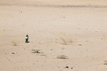 A woman carries two bottles of water as she walks across a drought affected landscape in a region, where most people are pastoralists and are relying on food aid. Ethiopia is experiencing its worst dr...