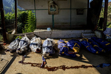 Blood and fluids drip from bags containing dead bodies that were recovered from the site of a landslide at an unofficial mine. They were not claimed by family members and now lie inside the compound o...