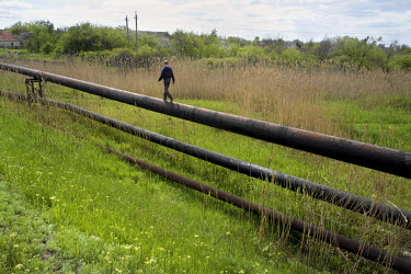 A boy walks along a water pipe (supplying non-potable water). Krasnohorivka used to get its drinking water supplies from Donetsk, but these were stopped after hostilities broke out between pro-Russian...
