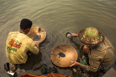 Jade miners take a break from digging to try their luck panning for gold in a lake at the site of a jade mine.