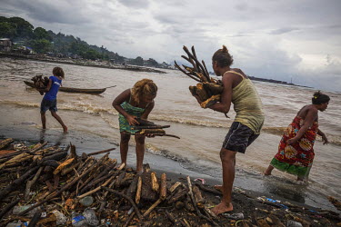 Young women from Lord Howe Settlement, an area in the Solomon Islands' capital Honiara, collecting firewood that floated to their shores during flood. In February 2015, on Guadalcanal Island, tropical...