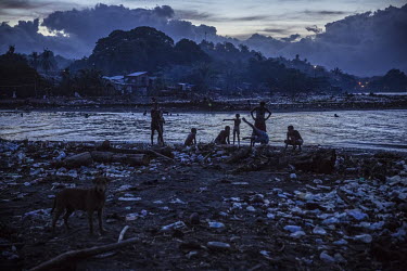 Children playing at dusk among the debris on the beach in Lord Howe Settlement, a district of the capital Honaria populated by people from Ontong Java Atoll (AKA Lord Howe Atoll), a Polynesian outlier...