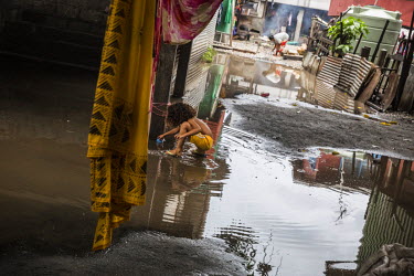 A child plays in a puddle between houses in Lord Howe Settlement, which gets flooded after every heavy rain storm.  Lord Howe Settlement, a district of the capital Honaria, is populated by people from...