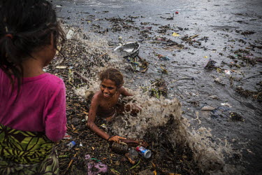Girls play in a see among rubbish and debris that we brought to the shores of Lord Howe Settlement by Mataniko River during a flood. In February 2015, on Guadalcanal Island, tropical rains fell almost...