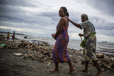 A young women helps her grandmother to walk through the garbage in Lord Howe Settlement, a district of the capital Honaria populated by people from Ontong Java Atoll (AKA Lord Howe Atoll), a Polynesia...