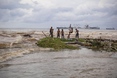 Boys playing among debris and logs that were carried to the shore of their settlement by flooding on the Mataniko River. In February 2015, on Guadalcanal Island, tropical rains fell almost non-stop. T...