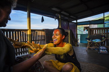 Ella Keahi, 55, helps her 18 year old niece Jessica to put on 'hala'ei', a turmeric paint that women and girls from Ontong Java Atoll apply when they participate in cultural shows, traditional celebra...