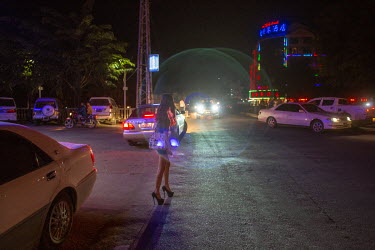 A Chinese sex worker walks down a street near the red light district area at night in Mong La.  The town of Mong La on the Burma - China border in western Burma (Myanmar) is technically in Burma but r...