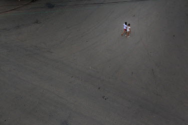 Two women walk across an empty street in Mong La.The town of Mong La on the Burma - China border in western Burma (Myanmar) is technically in Burma but relies on most infrastructure - electricity, tel...
