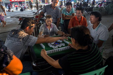 Men play Chinese Mahjong in the market in Mong La.  The town of Mong La on the Burma - China border in western Burma (Myanmar) is technically in Burma but relies on most infrastructure - electricity,...