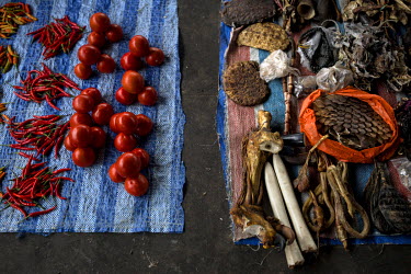 Tiger paws, tiger penis, pangolin scales and other wildlife products are on sale next to a stall selling tomatoes and spices, in the market of the border-town Mong La.  The town of Mong La on the Burm...