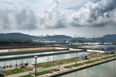 A new set of locks at the Pacific end of the Panama Canal while beyond a ship pases through the original Miraflores lock. When the Panama Canal Expansion is complete, 26 June 2016, ships specified as...