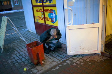Sasha sniffing glue at the entrance to a shop. He lives in a basement with other homeless youths.