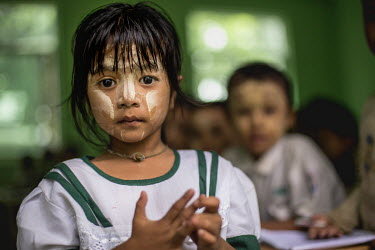 A girl with traditional tha-na-ka paste on her face in a classroom at a monastic school in Yangon.