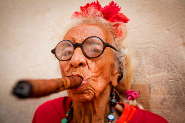 An elderly woman who makes a living posing for tourists while smoking an enormous cigar. She charges one US Dollar for a picture.
