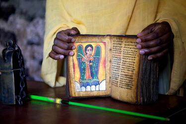 An orthodox Christian woman displays a Bible at the Entos Eyesu Monastery located on an island in Lake Tana.