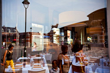 Reflections of people in a window of the brasserie restaurant La Paix.