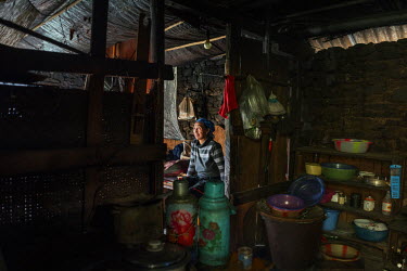 Naye Bu, 60, a Lisu villager sits in the home, above the bank of the Nujiang River, she has shared with her husband for 30 years.