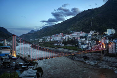 A bridge crossing the Nujiang River is illuminated by strings of lights in Fugong, one of the largest towns in the Nu River valley.