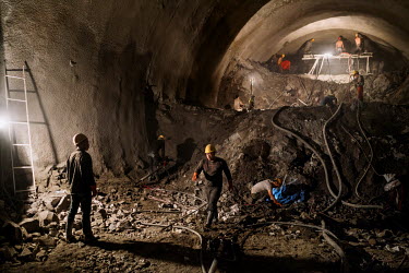 Construction workers work inside the 'Huo Po Tunnel' construction project that will allow a highway to run between Baoshan and Liuku, the gateway to the Nujiang River valley.