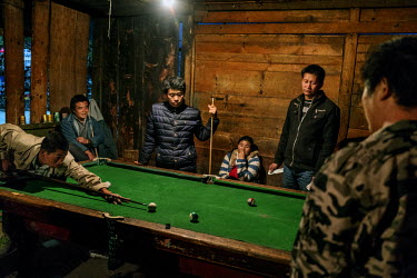 Local youngsters play pool and gamble in a bar.