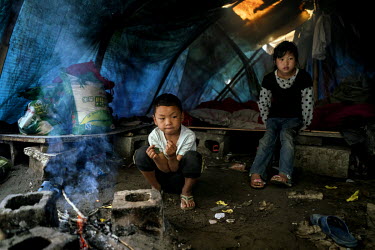 Children whose father works on a nearby construction site inside the shelter where the family live close to the Nujiang River.