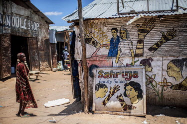 A young refugee looks at murals on the wall of a beauty salon in Dadaab refugee camp.